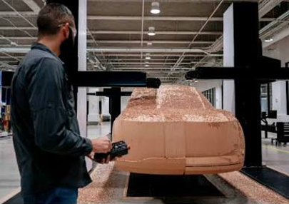 Design team assessing a freshly milled clay model in the studio, checking whether refined digital surfaces still feel right in physical space under real lighting