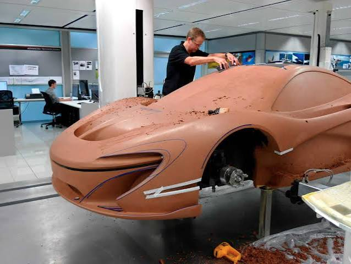 Clay modeler and digital modeler working together in a design studio, refining form and surface quality through close collaboration between physical and digital disciplines