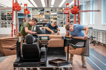 Design studio team reviewing a clay model alongside digital screen data, demonstrating the partnership between clay and digital roles in the modern automotive design process